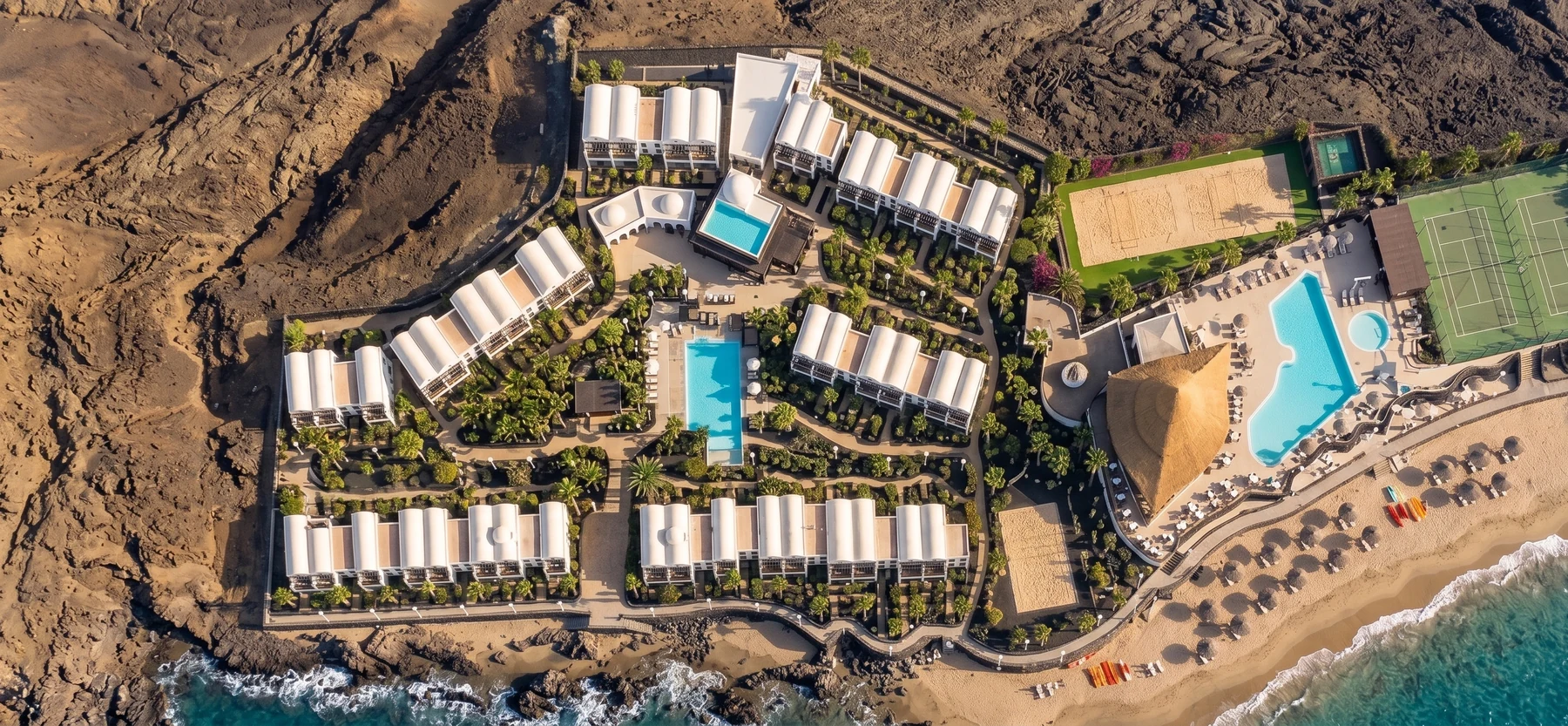 Aerial view of the MONEA Royal Mónica in Playa Blanca, Lanzarote: room blocks, pools, sports courts and beach